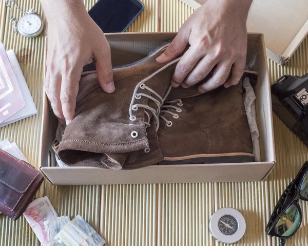 Man hand holding a pair de boots of the box — Stock Photo, Image