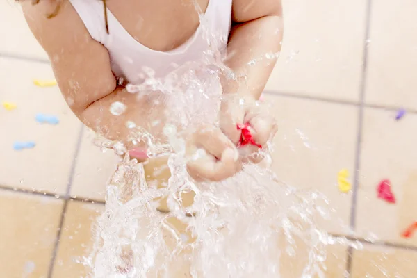 Lilla flickan plaskade ett vatten ballon — Stockfoto