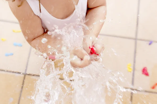 Ragazzina spruzzando un palloncino d'acqua — Foto Stock