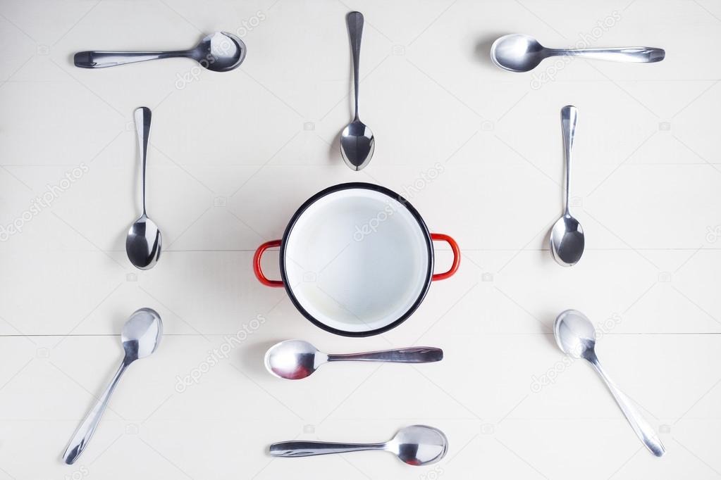 Top view of empty pot with spoons on symmetry