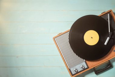 Yeşil ahşap masa üzerinde vinil plaklı klasik gramofon, üst görünüm ve boşluk kopyala.