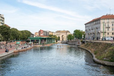 Milan, İtalya-Eylül 29,2020: İnsanlar Naviglio Milano kanalı boyunca yürüyor ve Coronavirus salgını sırasında barlarda dinleniyor (Covid-19) Darsena bölgesi, su üzerinde kano sporu yapan diğer insanlar.