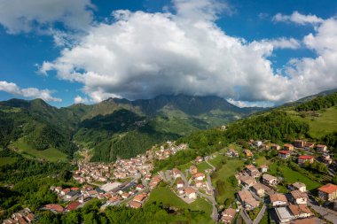 Drone aerial view to the Seriana valley and Orobie Alps with big cloud and blue sky