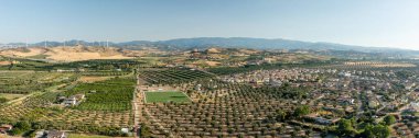 Calabria iç kesiminin panoramik görüntüsü, arka planda zeytin alanları ve rüzgar türbinleri, Calabria, İtalya.