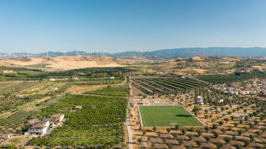 Calabria iç kesiminin panoramik görüntüsü, arka planda zeytin alanları ve rüzgar türbinleri, Calabria, İtalya.