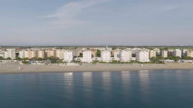 Şemsiyeli, balkonlu ve arka plandaki kumlu sahil manzarası. Lido Adriano şehri, Adriyatik kıyısı, Emilia Romagna, İtalya.