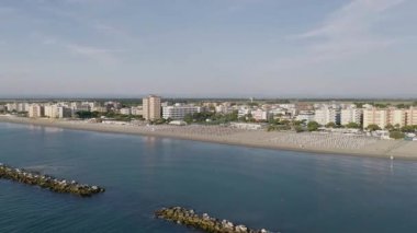Şemsiyeli, balkonlu ve arka plandaki kumlu sahil manzarası. Lido Adriano şehri, Adriyatik kıyısı, Emilia Romagna, İtalya.