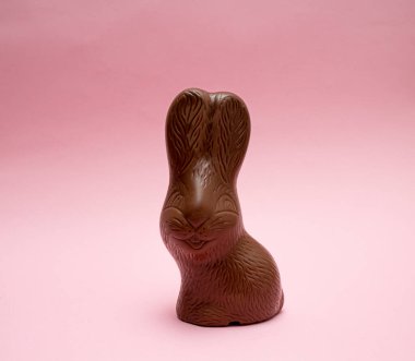 Pembe arka planda çikolatalı Paskalya tavşanı. Bahar tatili kavramı