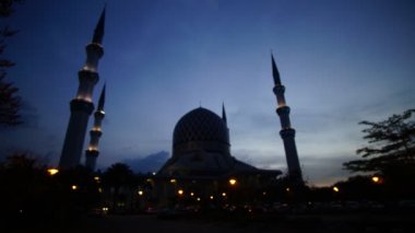 Shah Alam Camii zaman atlamalı bulutlu gün batımı sırasında.