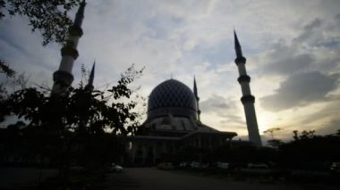 Shah Alam Camii zaman atlamalı bulutlu gün batımı sırasında.