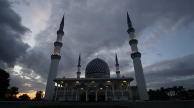 Shah Alam Camii zaman atlamalı bulutlu gün batımı sırasında.