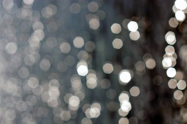 Gölün etrafındaki çit bulanık ve güneş suyun üzerinde parlıyor.