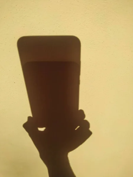 Σκιά Κίτρινο Τοίχο Μορφή Χεριών Και Smartphone — Φωτογραφία Αρχείου