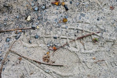 Asfalt taşlarının dokusu ve yerde kum.