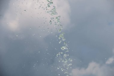 Gökyüzünün arka planındaki çeşmeden fışkıran su.