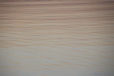 Gün batımı göletteki suda parlıyor.