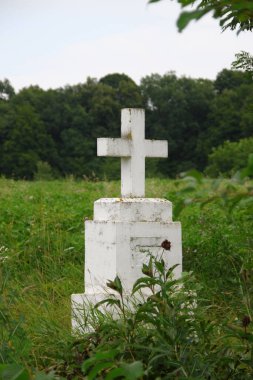 Beyaz çimlerin üzerinde beyaz beton bir Hıristiyan haçı