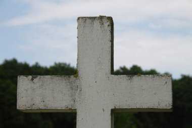 Beyaz çimlerin üzerinde beyaz beton bir Hıristiyan haçı