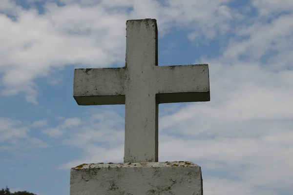 白色混凝土基督教十字架在草地背景下的田野里 — 图库照片