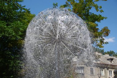 Parktaki bir çeşmede su fışkırıyor.
