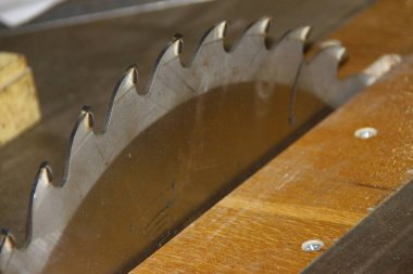Atölyedeki dairesel testere üzerinde büyük parlak metal bir testere.
