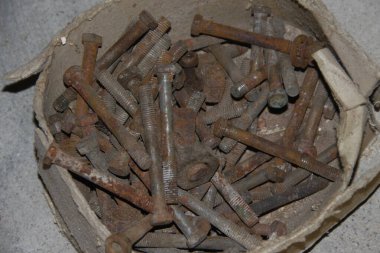 Atölyede büyük metal vidalar ve fındıklar var.