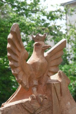 Polonyalı bir kuşun beton heykeli sarıya boyanmış.