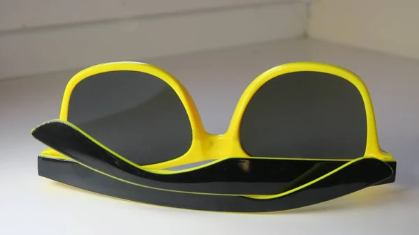 Yellow-black sun protective goggles in hand