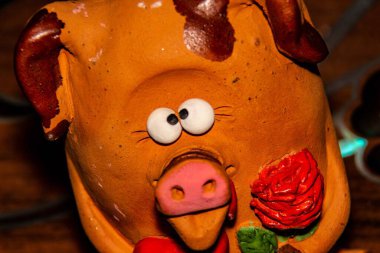 Oyuncak gözlü domuz, kilden yapılmış, çiçek ve kalpten.