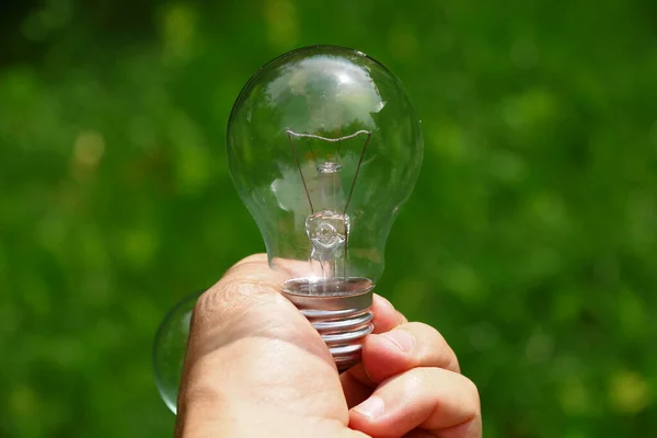Non-working glass incandescent lamp in hand