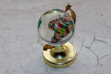 Masanın üzerindeki camdan yapılmış oyuncak küre.