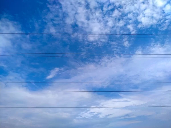Ağustos Elektrik Hatlarının Arka Planında Mavi Gökyüzü Beyaz Bulutlar — Stok fotoğraf