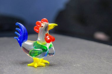 Siyah arka planda küçük cam horoz.