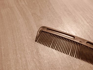 Odadaki masanın üzerinde siyah plastik tarak var.