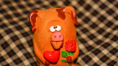 Bir çiçeğe aşık şaşı gözlü domuz yavrusu ve pençelerinde kırmızı bir kalp Sevgililer Günü 'nü ve 8 Mart Sevgililer Günü' nü, Anneler Günü 'nü kutluyor.