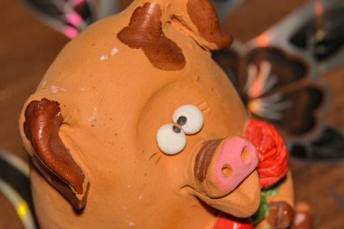 Bir çiçeğe aşık şaşı gözlü domuz yavrusu ve pençelerinde kırmızı bir kalp Sevgililer Günü 'nü ve 8 Mart Sevgililer Günü' nü, Anneler Günü 'nü kutluyor.