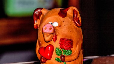 Bir çiçeğe aşık şaşı gözlü domuz yavrusu ve pençelerinde kırmızı bir kalp Sevgililer Günü 'nü ve 8 Mart Sevgililer Günü' nü, Anneler Günü 'nü kutluyor.