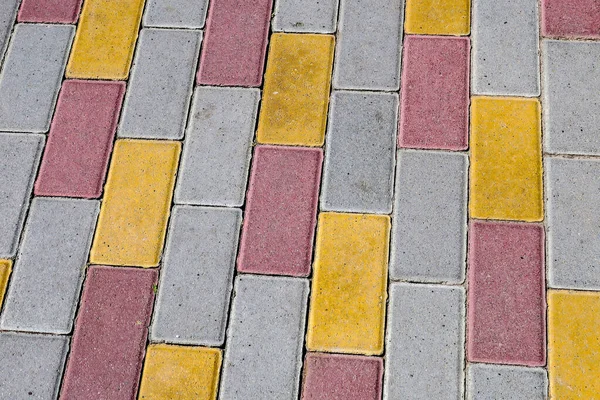 Kaldırımda kırmızı-sarı kaldırım taşlarının dokusu