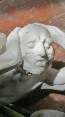 Düşünce içinde ellerini başının arkasında tutan bir adamın heykeli.