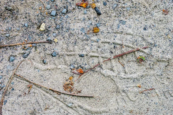 Asfalt taşlarının dokusu ve yerde kum.