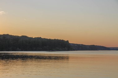 Gün batımı göletteki suda parlıyor.