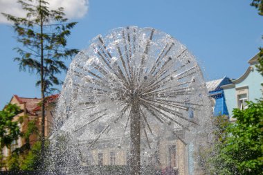 Parktaki bir çeşmede su fışkırıyor.