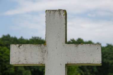 Beyaz çimlerin üzerinde beyaz beton bir Hıristiyan haçı
