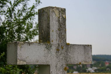 Beyaz çimlerin üzerinde beyaz beton bir Hıristiyan haçı