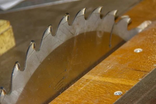 A large shiny metal saw on a circular saw in the workshop