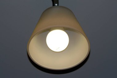 Odadaki tavanda şarap kadehi olan lamba.