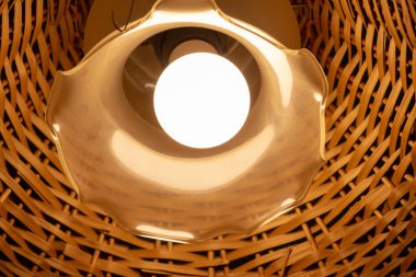 Tavanda ahşap bir abajur olan güzel bir lamba.