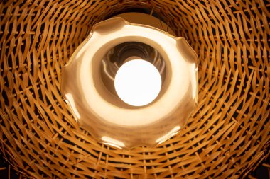 Tavanda ahşap bir abajur olan güzel bir lamba.