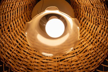 Tavanda ahşap bir abajur olan güzel bir lamba.