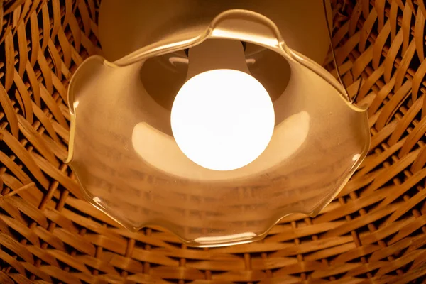 Tavanda ahşap bir abajur olan güzel bir lamba.